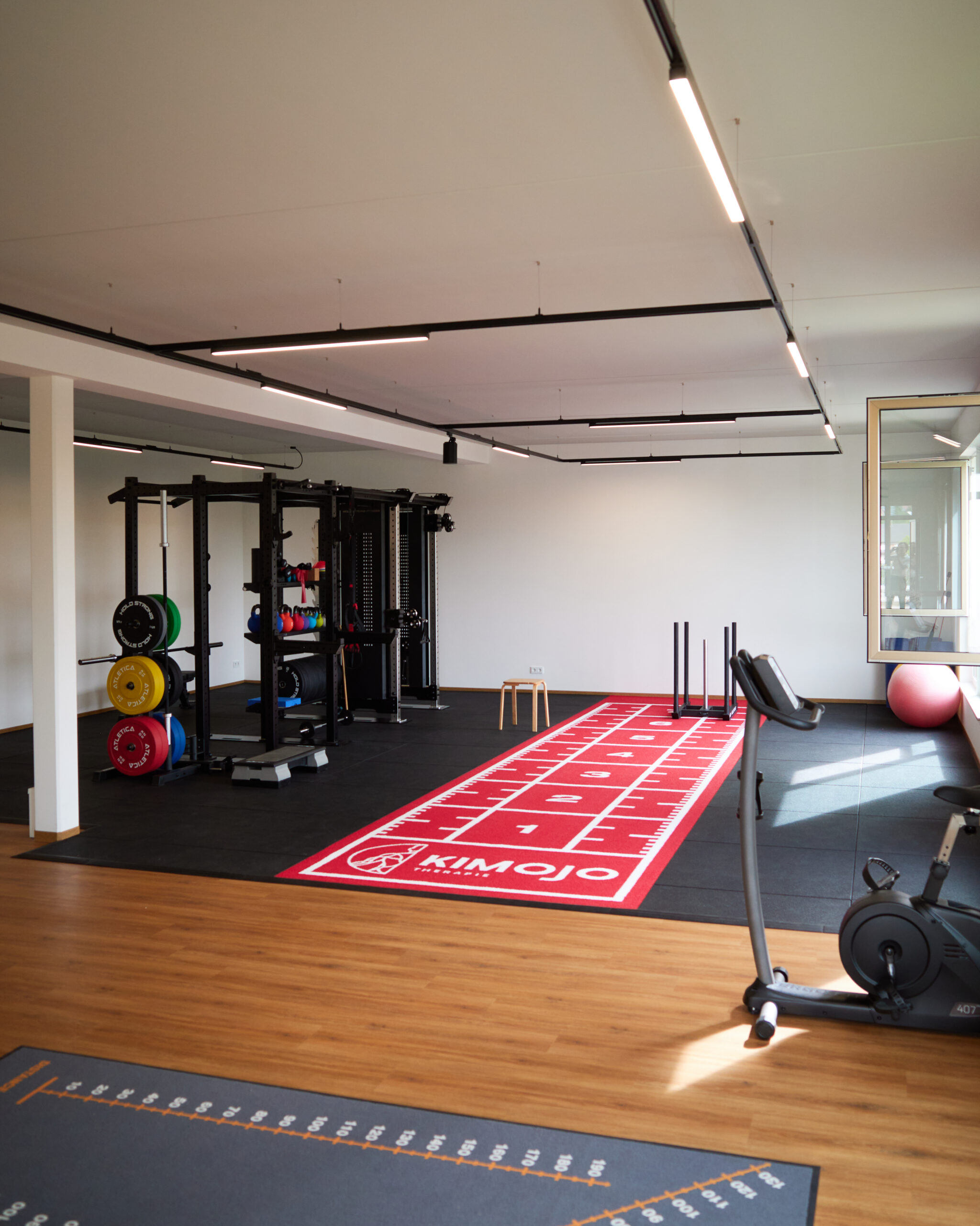 Blick über die Trainingsfläche mit Rig, Sprintbahn und Ausdauergeräten